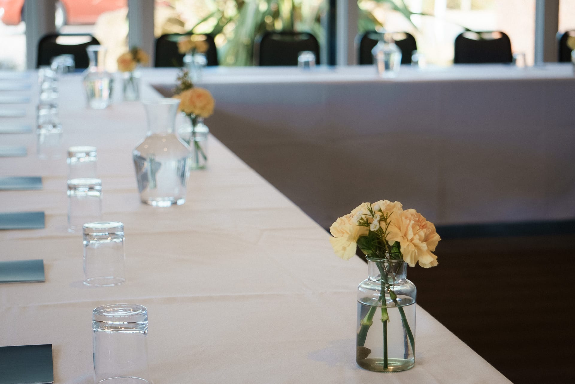 large table setup for a meeting in woking with flowers and glasses