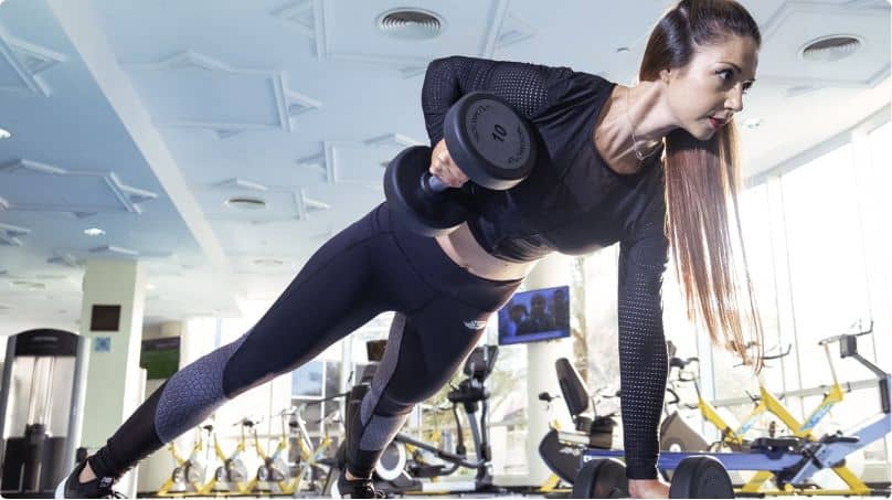 female working out with dumbbells at a gym in woking