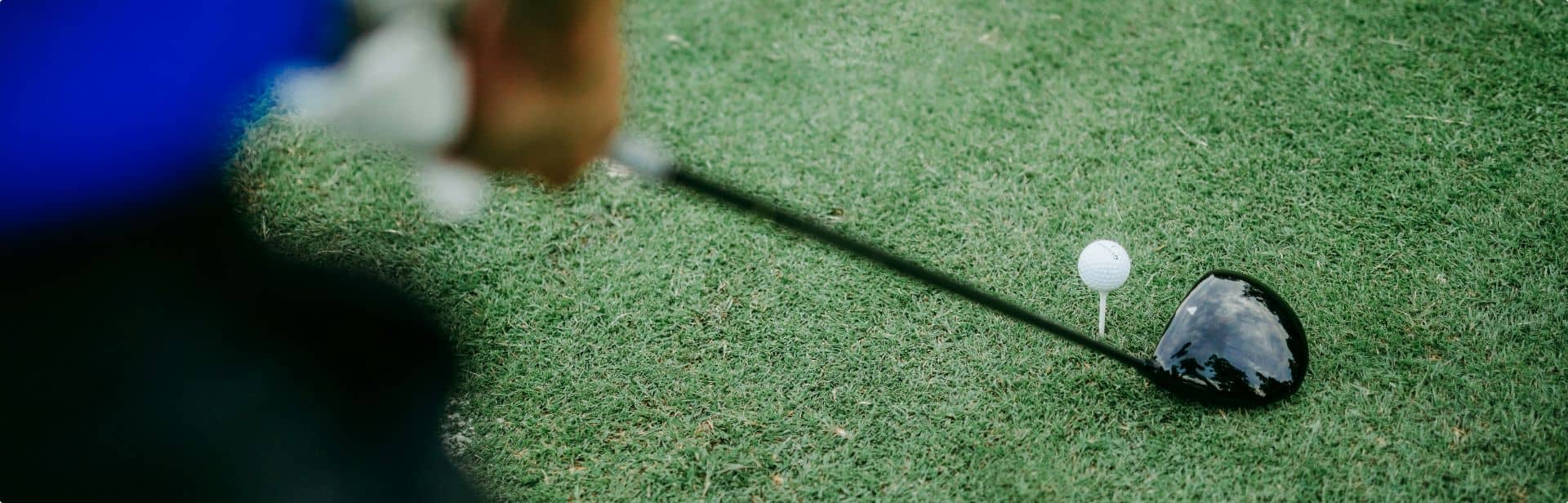 lining up golf club with a golf ball at a friendly golf course in woking