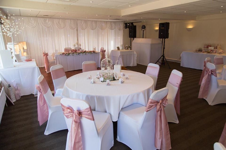 Elegant wedding table setup at a wedding venue in Woking, featuring floral centerpieces, candles, and fine tableware for a romantic wedding reception in Woking