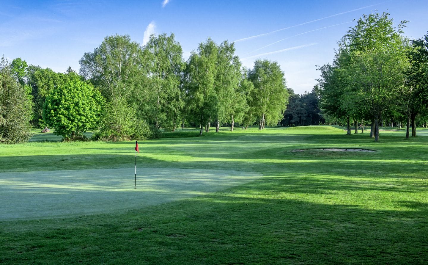 Golf green in the morning with mist rising over the fairway at a golf course in Woking
