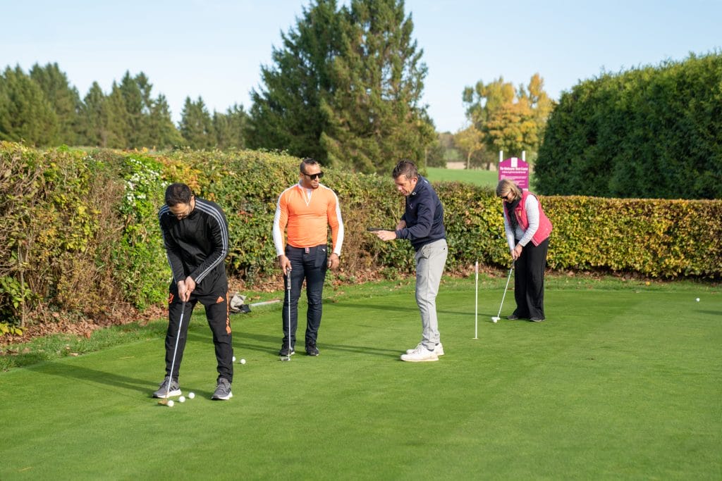golf coach teaching a group putting lesson in woking