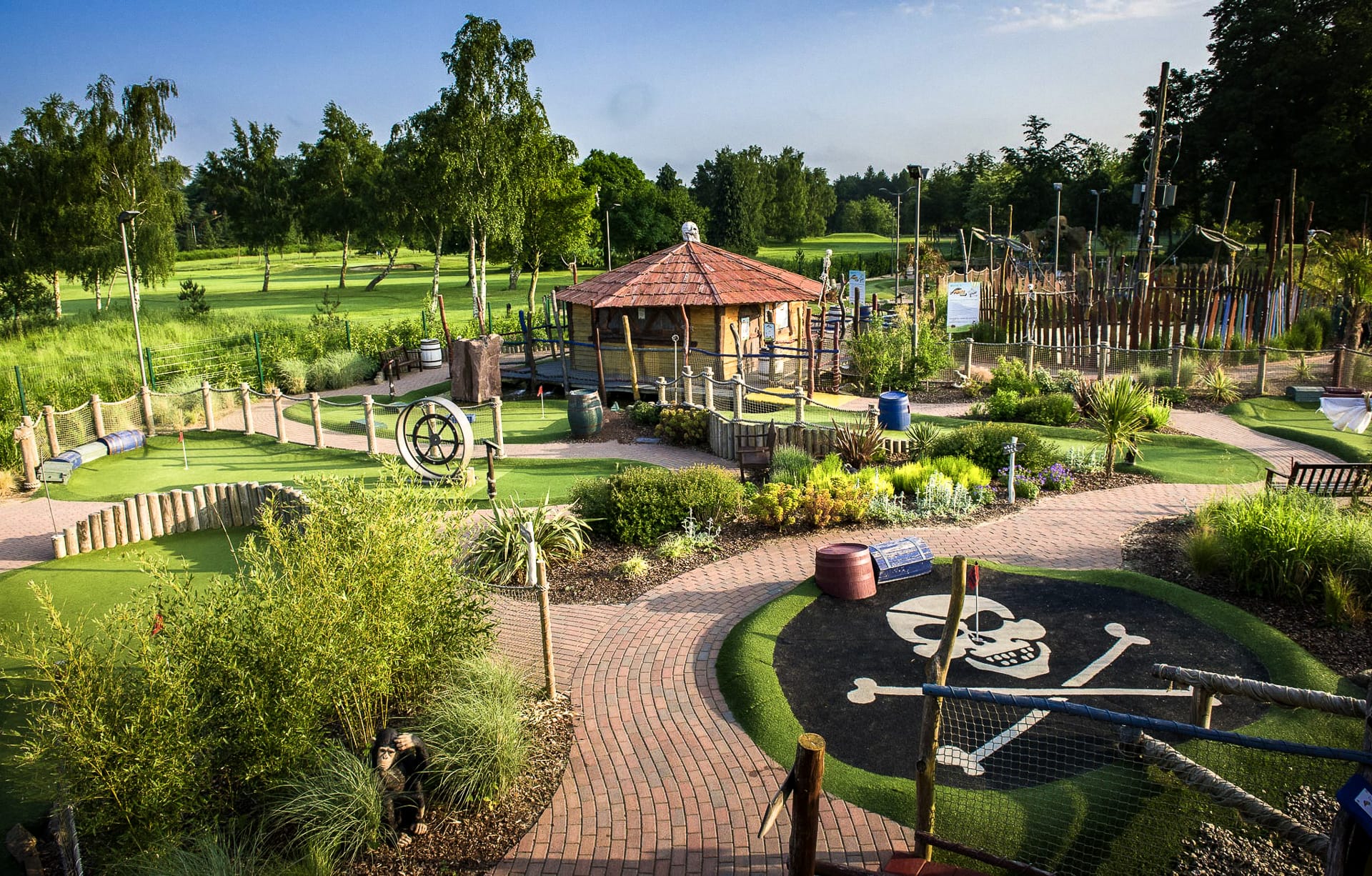 A pirate-themed mini golf course in Woking, featuring shipwreck props, treasure chests, and palm trees surrounding a winding putting green