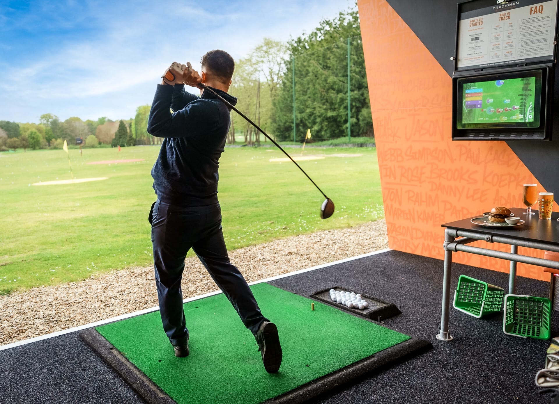 man hitting out of driving range bay in surrey with launch monitor
