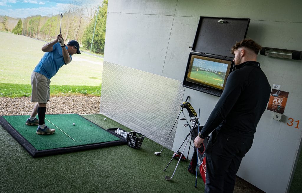 golf coach analysing players swing during golf lessons in Woking