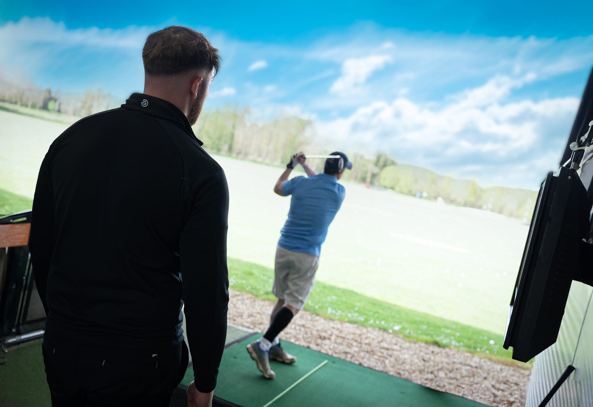 man getting a golf lesson in surrey at hoebridge driving range