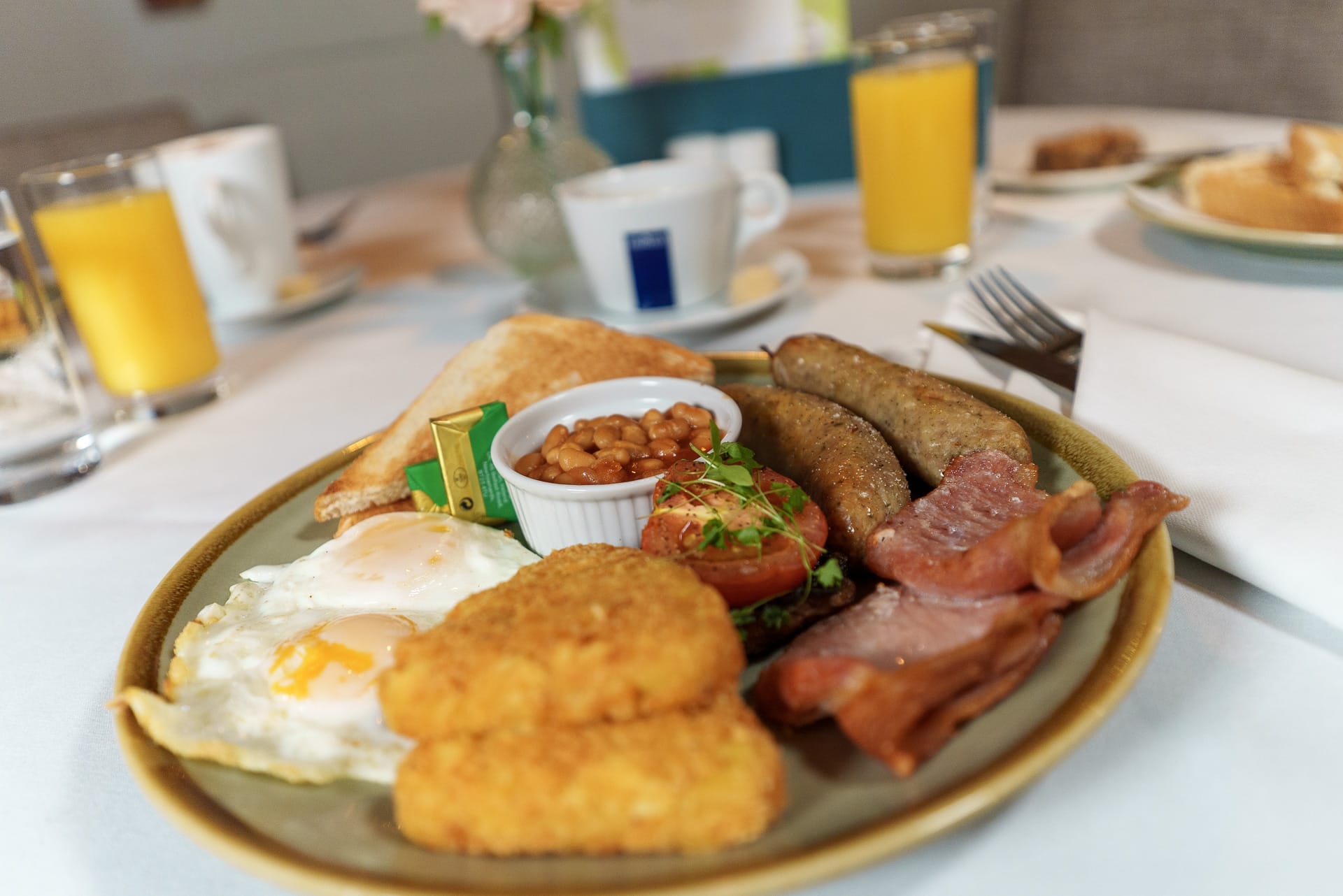 Traditional English breakfast plate served at a golf club in Surrey, featuring eggs, bacon, sausages, beans, and toast