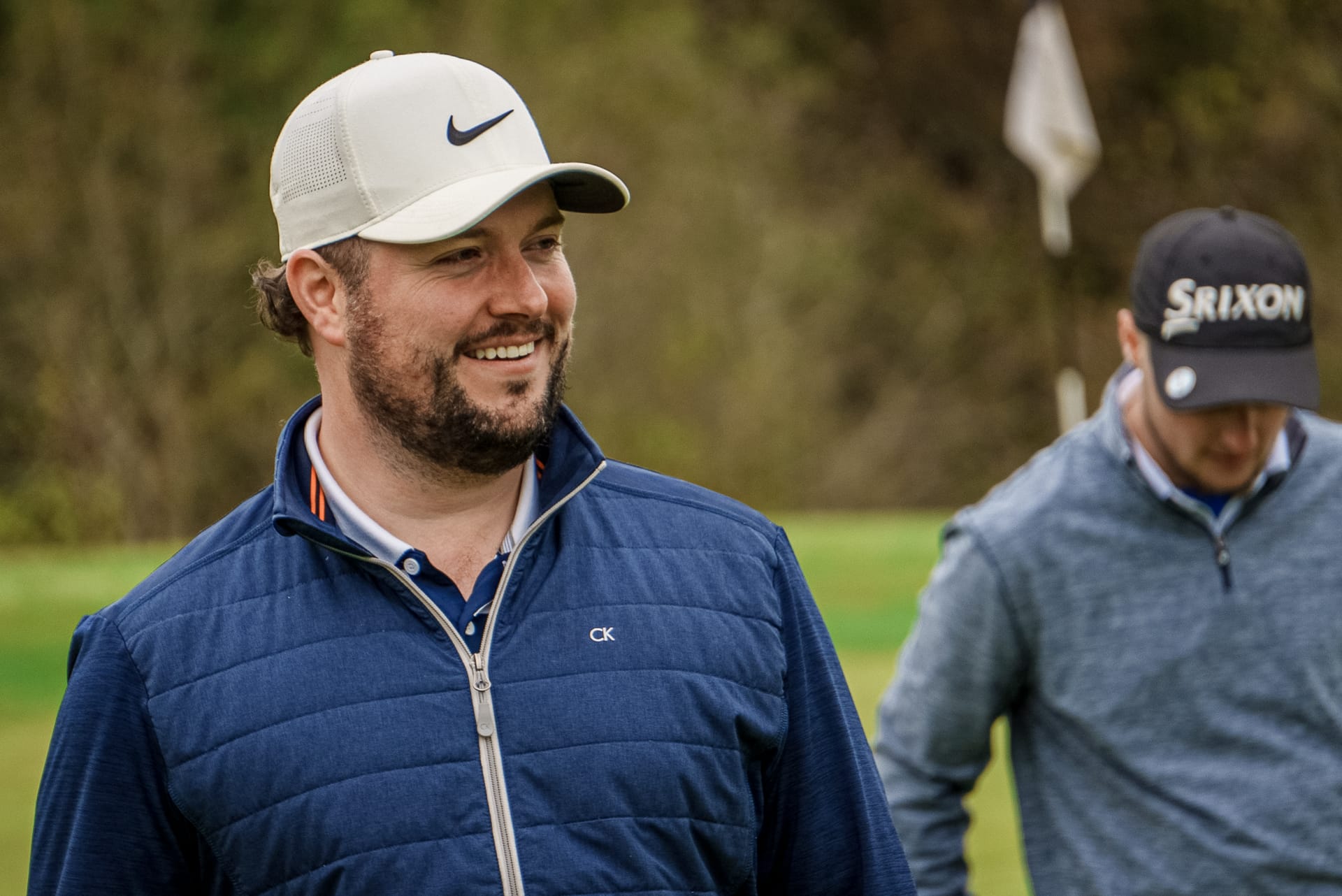 Golfer smiling on a golf course in Woking with friends