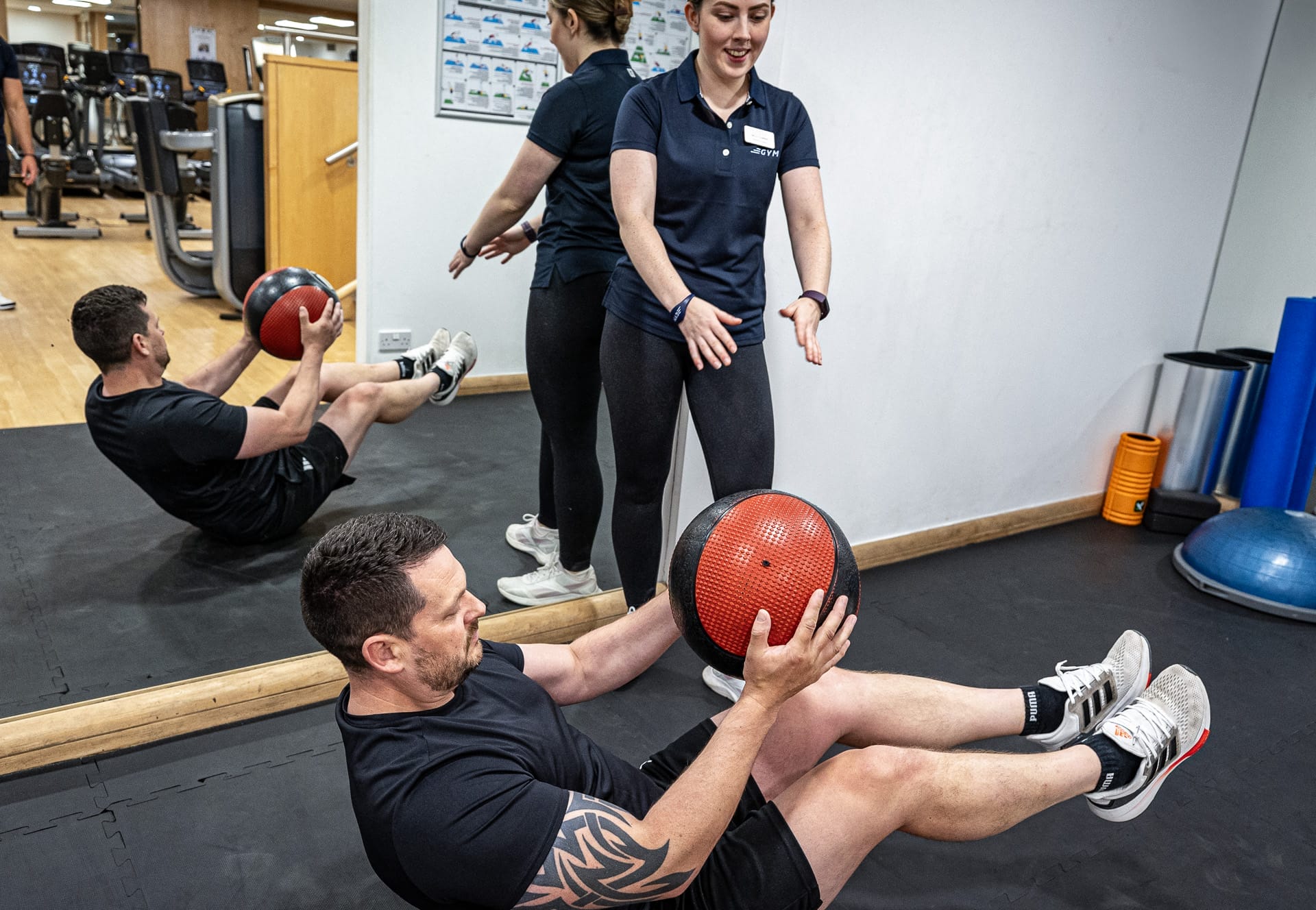 man using medicine ball at gym near woking
